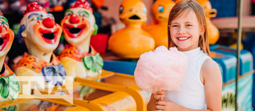Caucasian girl enjoying cotton candy at a carnival