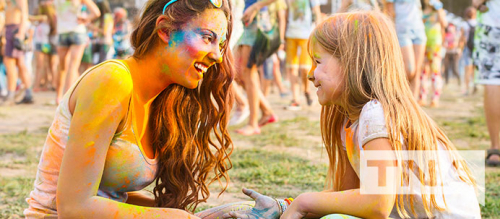 Mother and daughter covered in colour at a festival
