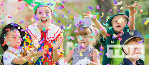 Kids in costume throwing confetti with a jester