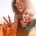 Woman on a mans shoulders holding up the peace sign at a music festival