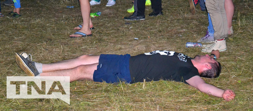 Man passed out on the grass at a concert