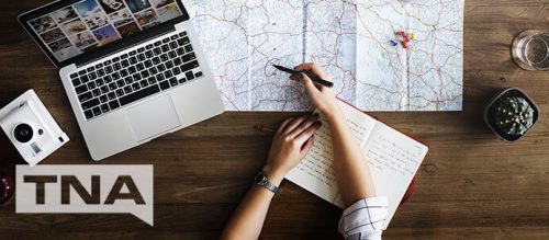 woman planning a holiday by bus with maps and laptop