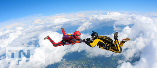 Two skydivers holding hands in a free fall
