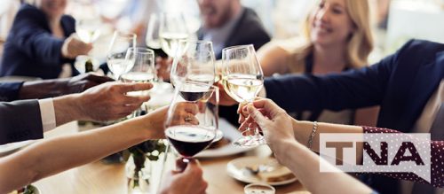 business people cheering with wine at a restaurant